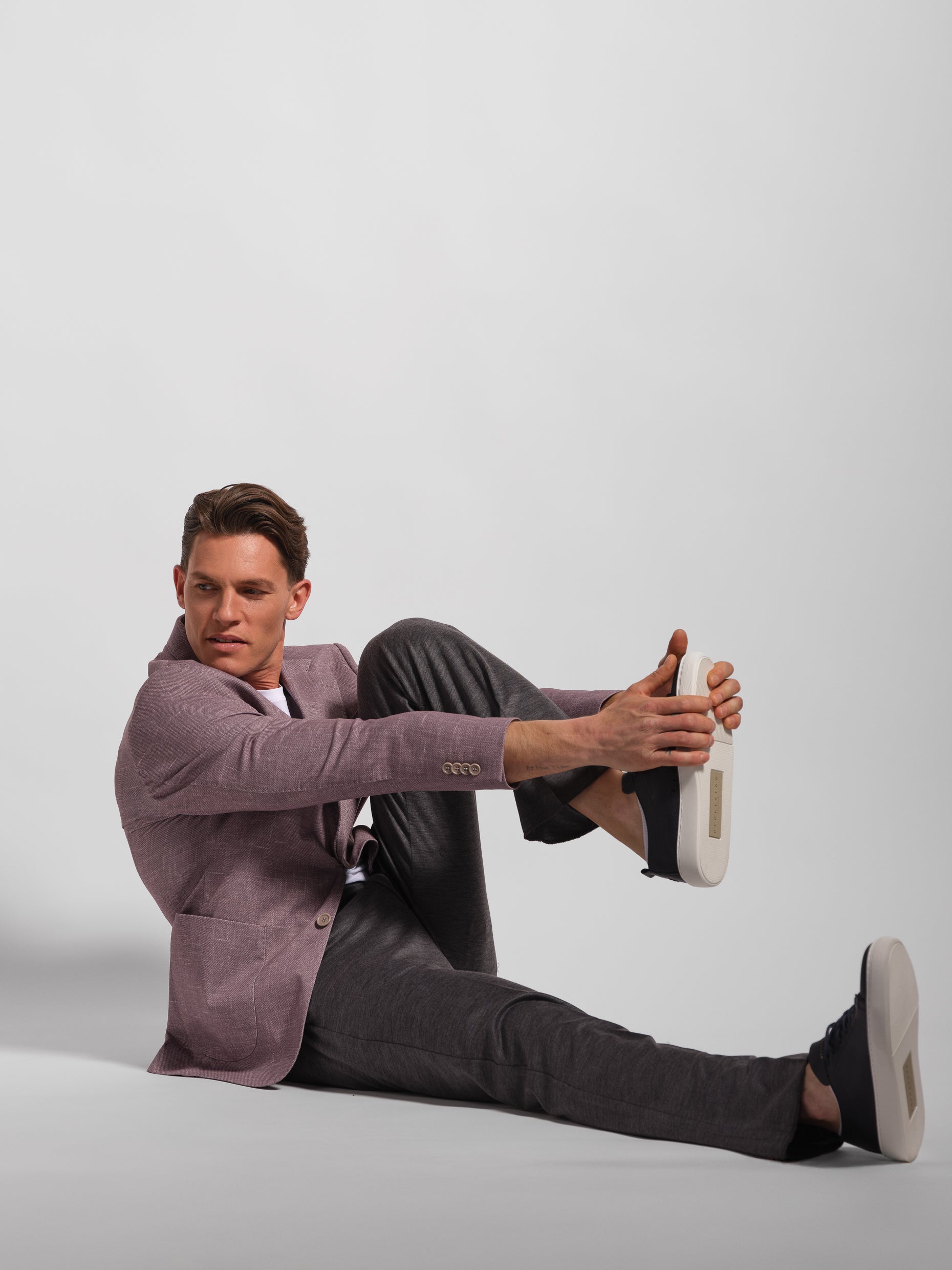 man stretch posing in purple stretch jersey suit