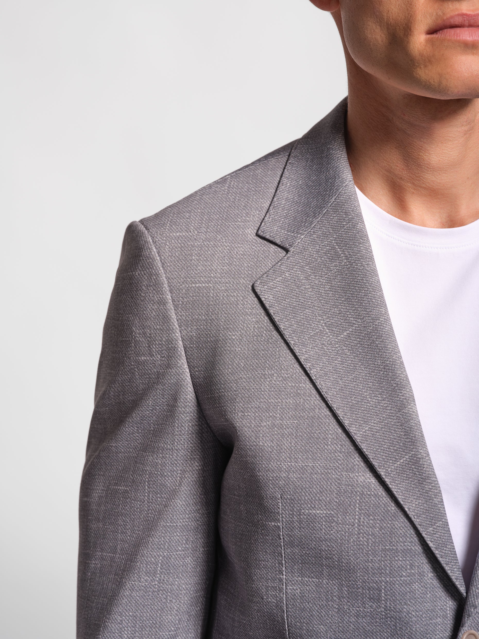 Gray blazer stretch jersey worn by a person , notch lapel