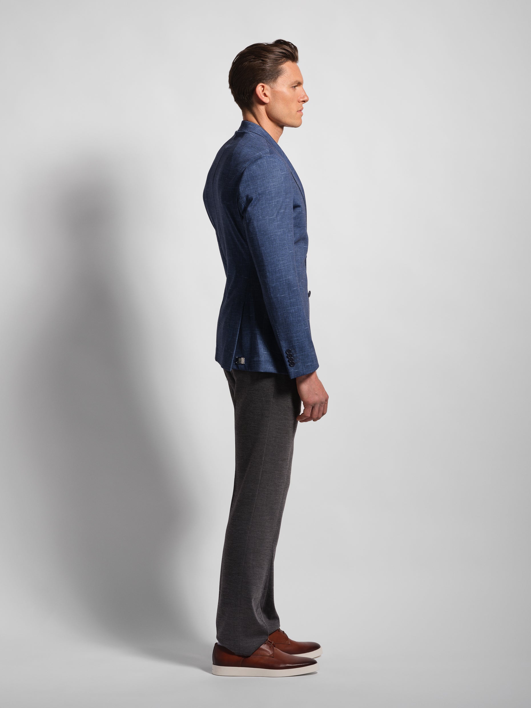 profile of a Man in a stretchy, comfortable Navy Jersey 2-button blazer jacket over a white t-shirt with navy pants wearing Man Wears Sheep in a very fitted jacket