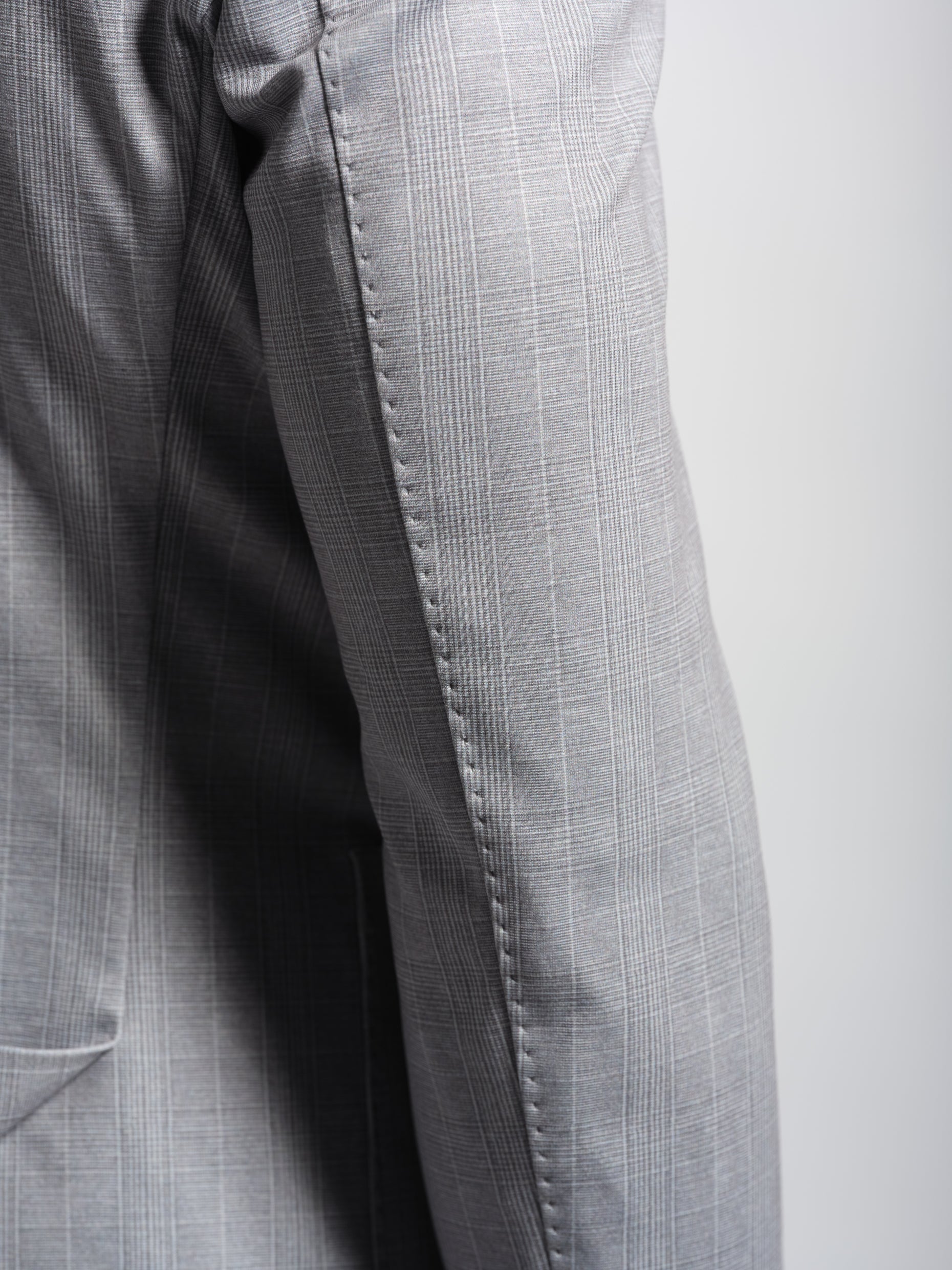 Close-up of gray checkered blazer with top stich
