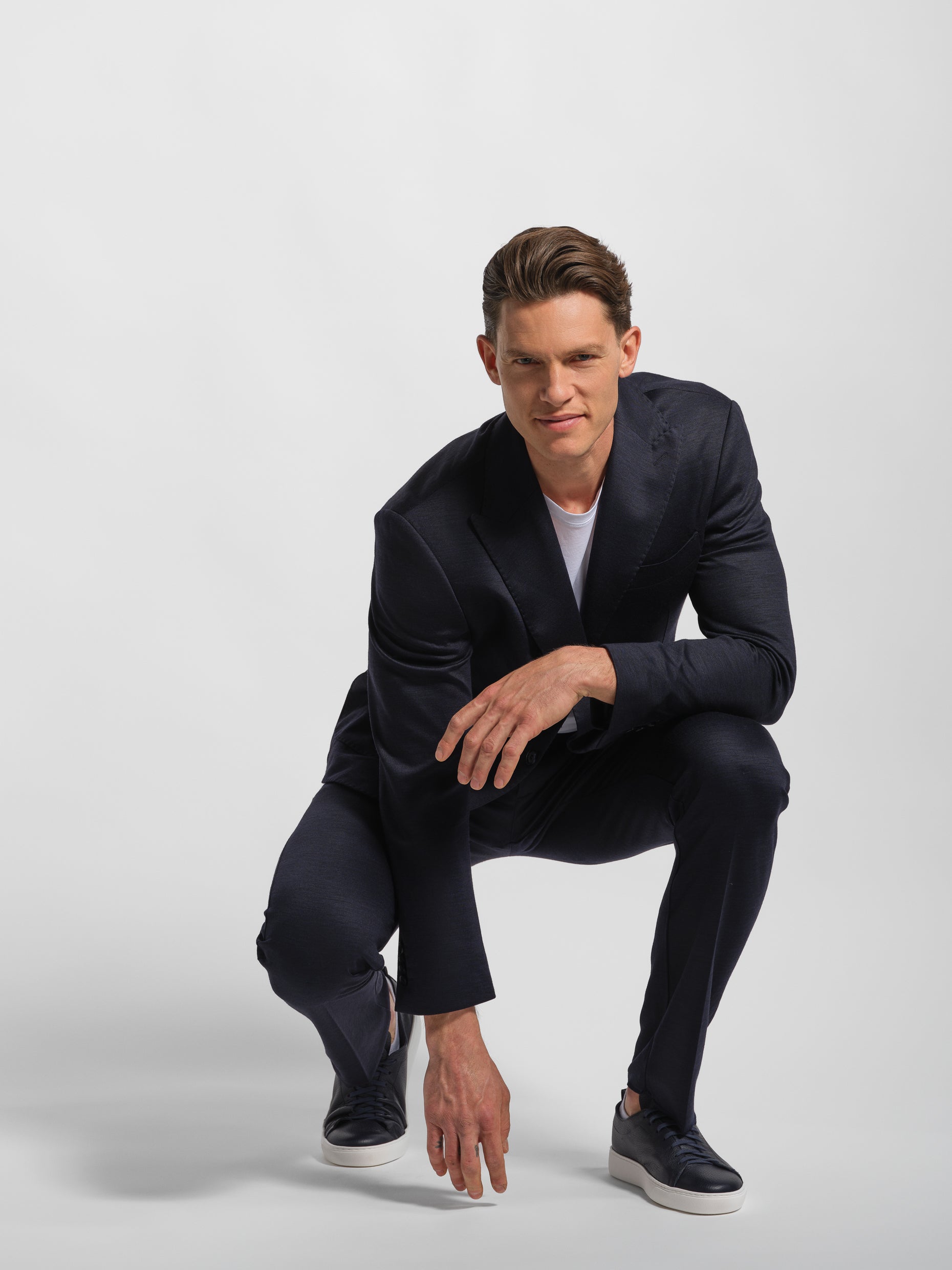 Man wearing a black jersey stretch suit suit posing