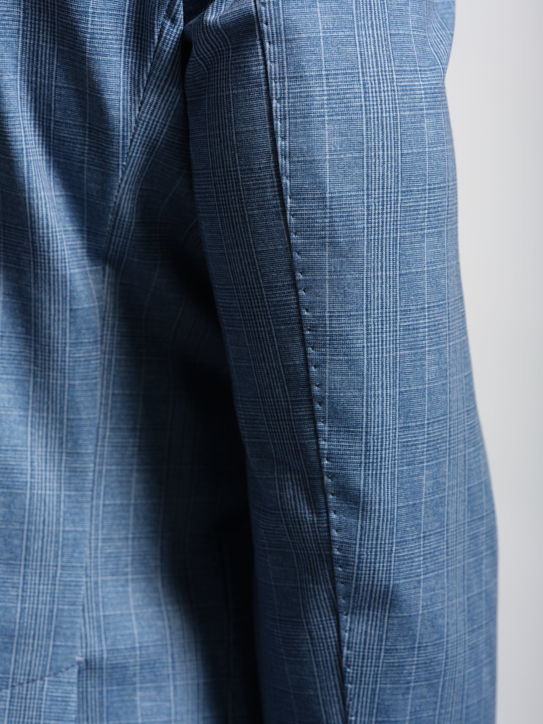 Close-up of a blue checkered suit jacket top stich and pic stitch
