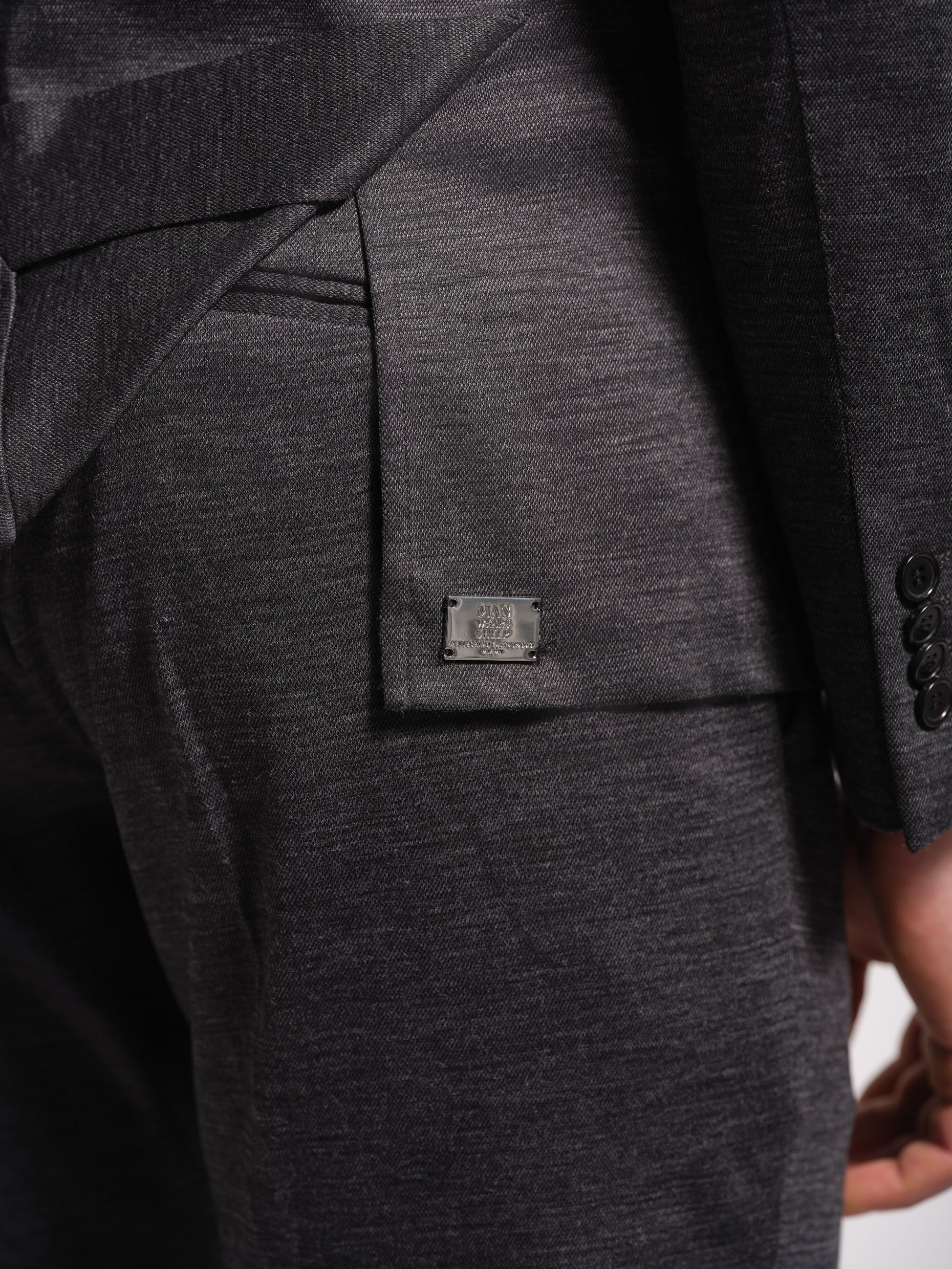 Close-up of a charcoal gray suit with a brand label