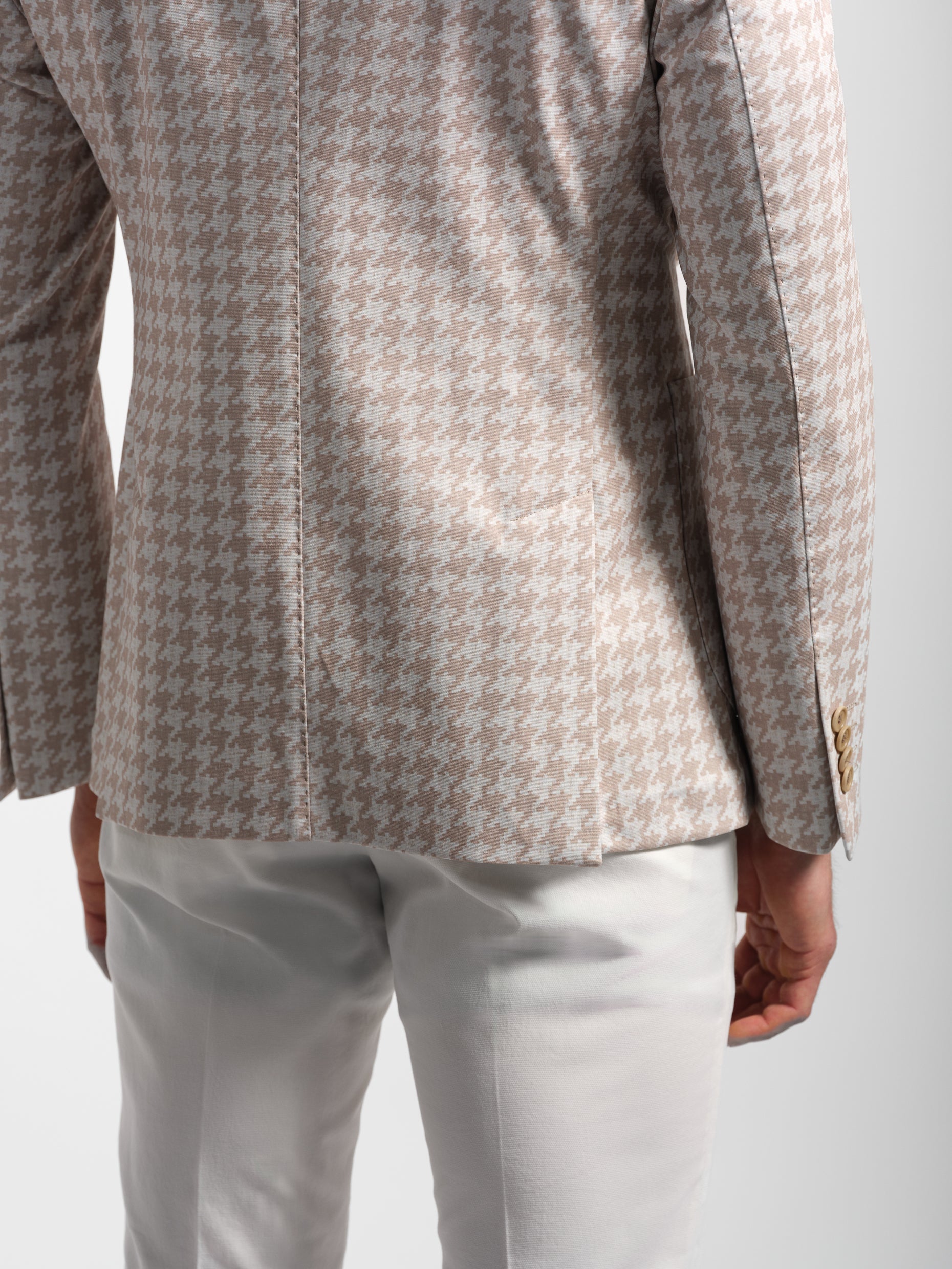 back close-up of a Houndstooth patterned blazer and white pants