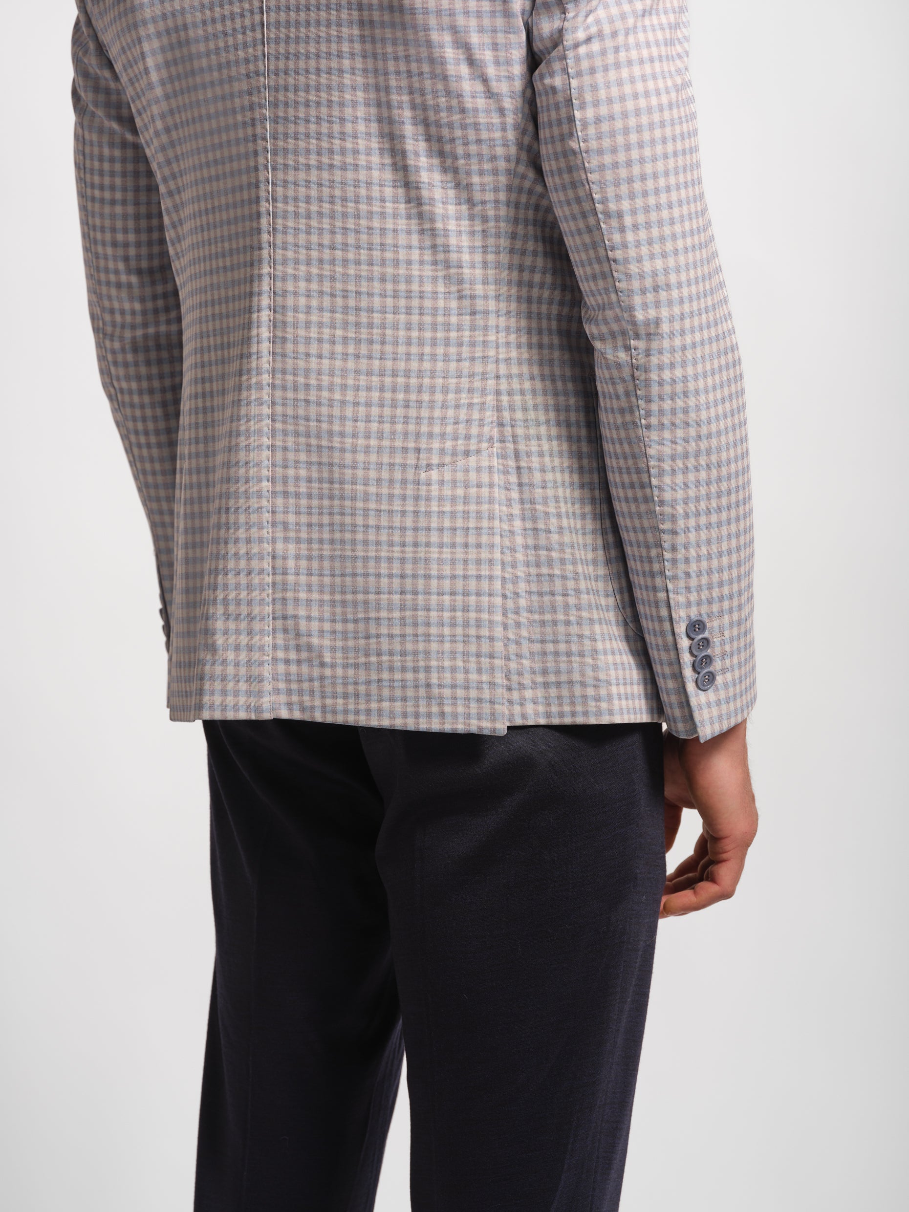 Gray checkered blazer with Navy pants on a man wears sheep double vents