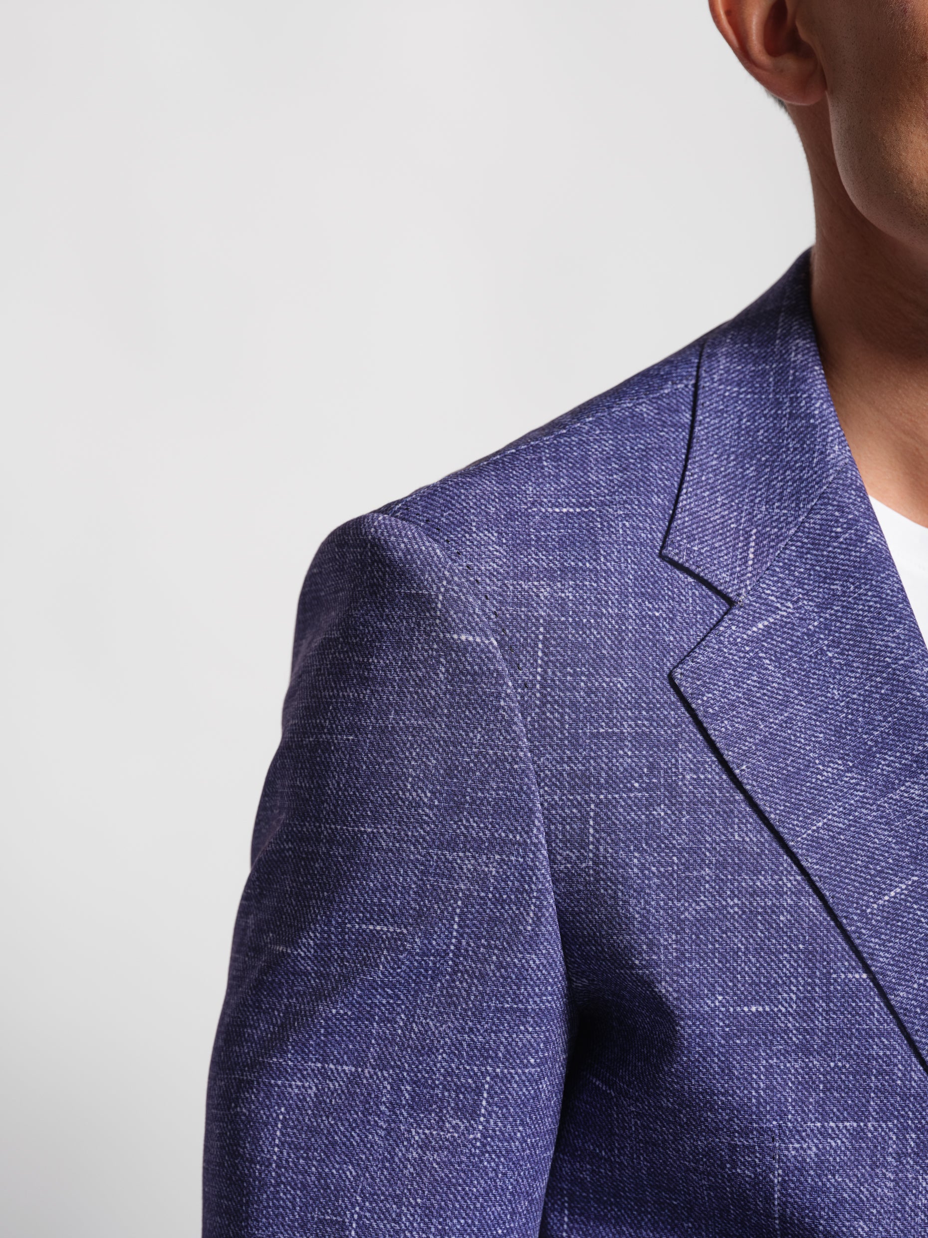 Close-up Man wearing a purple blazer over a white shirt with wide notch lapels and patch pockets top stitch