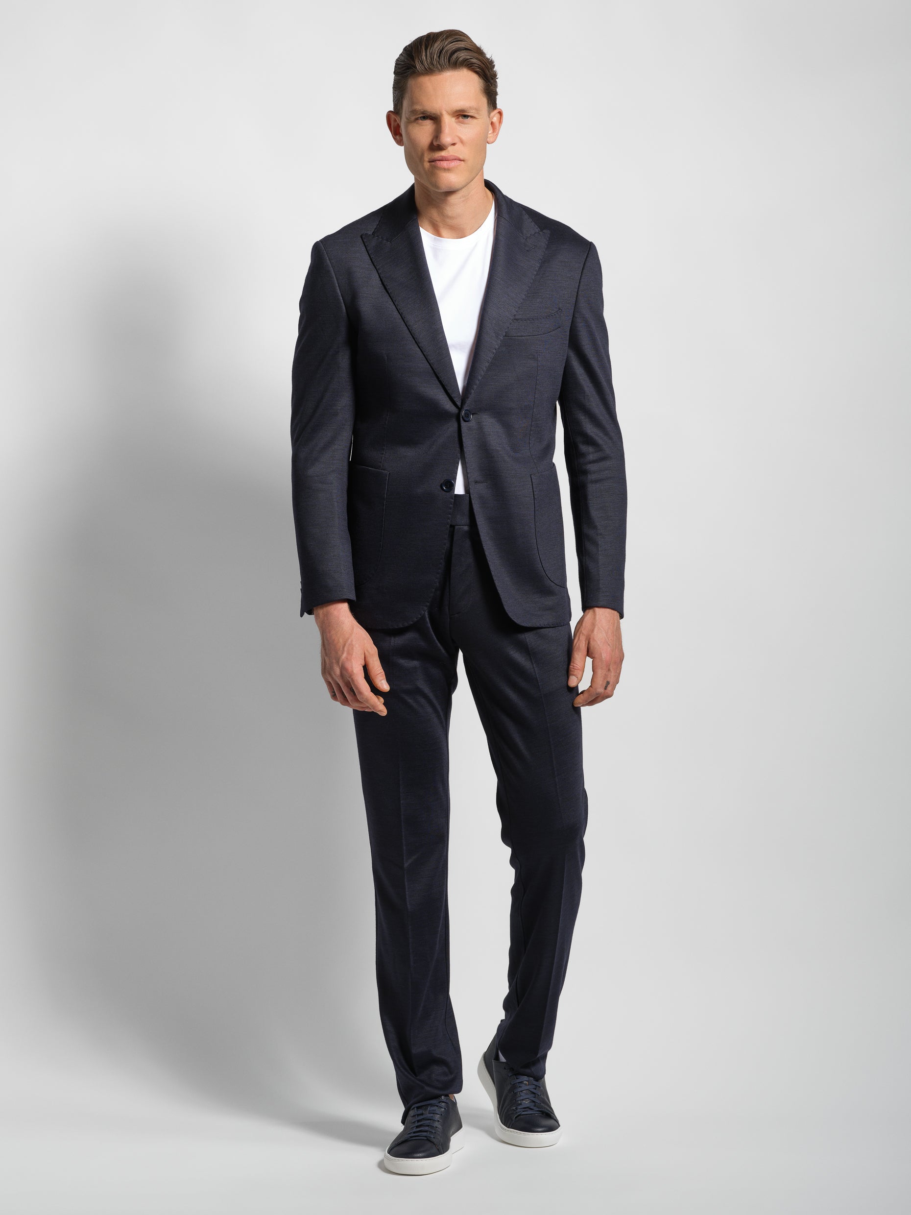 Navy jersey stretch suit man walking 2 button