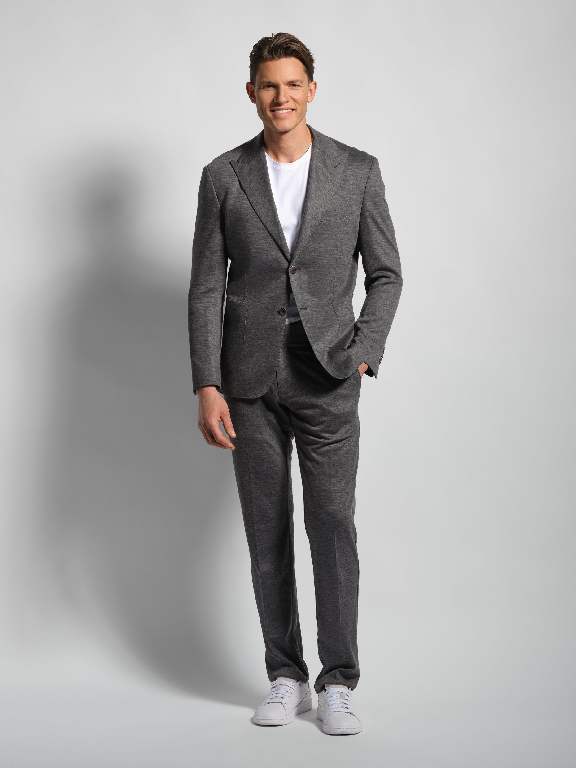 Man wearing a gray suit with a white shirt on a light peak lapels