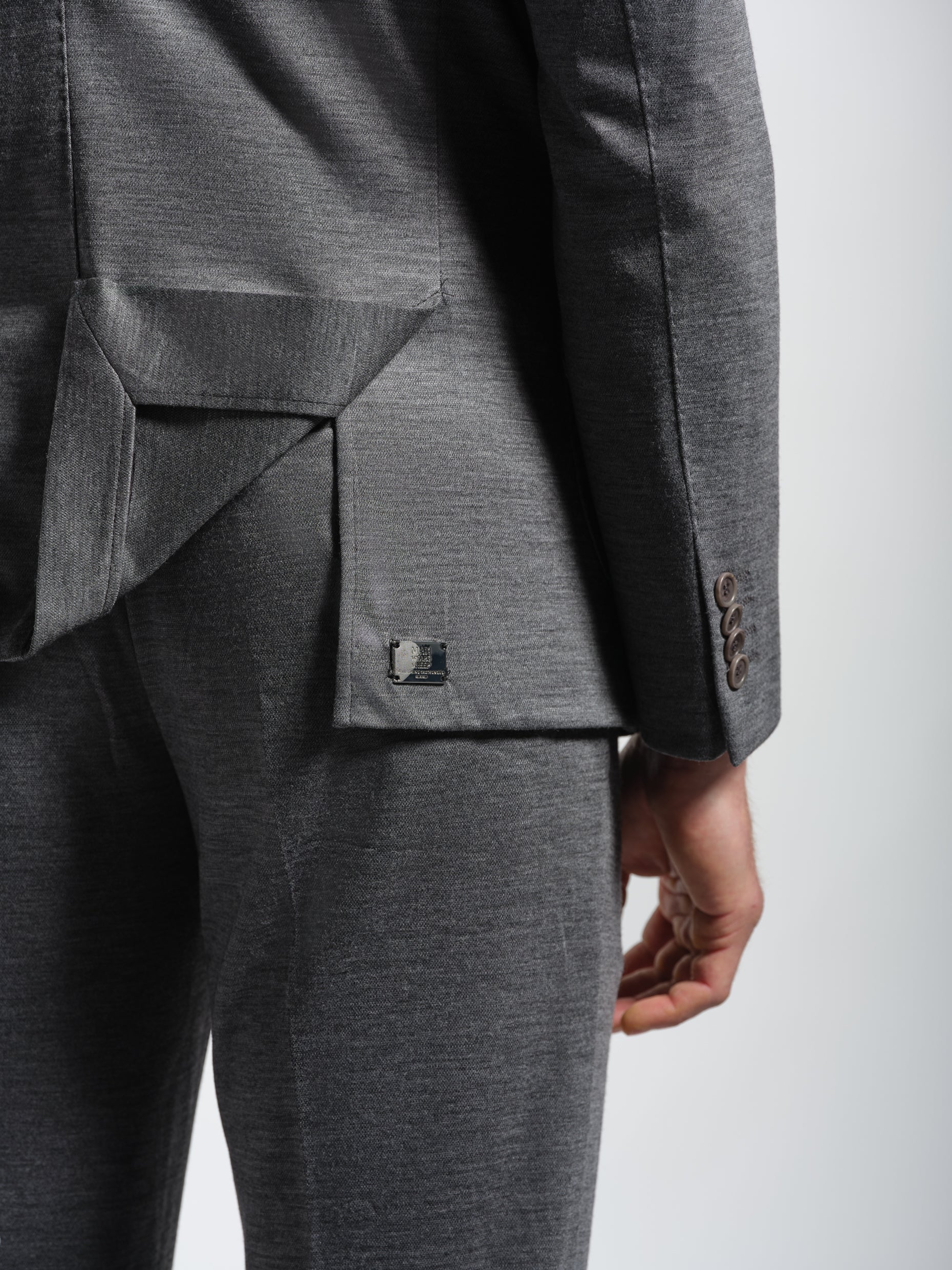 Gray suit jacket with a visible brand metal logo
