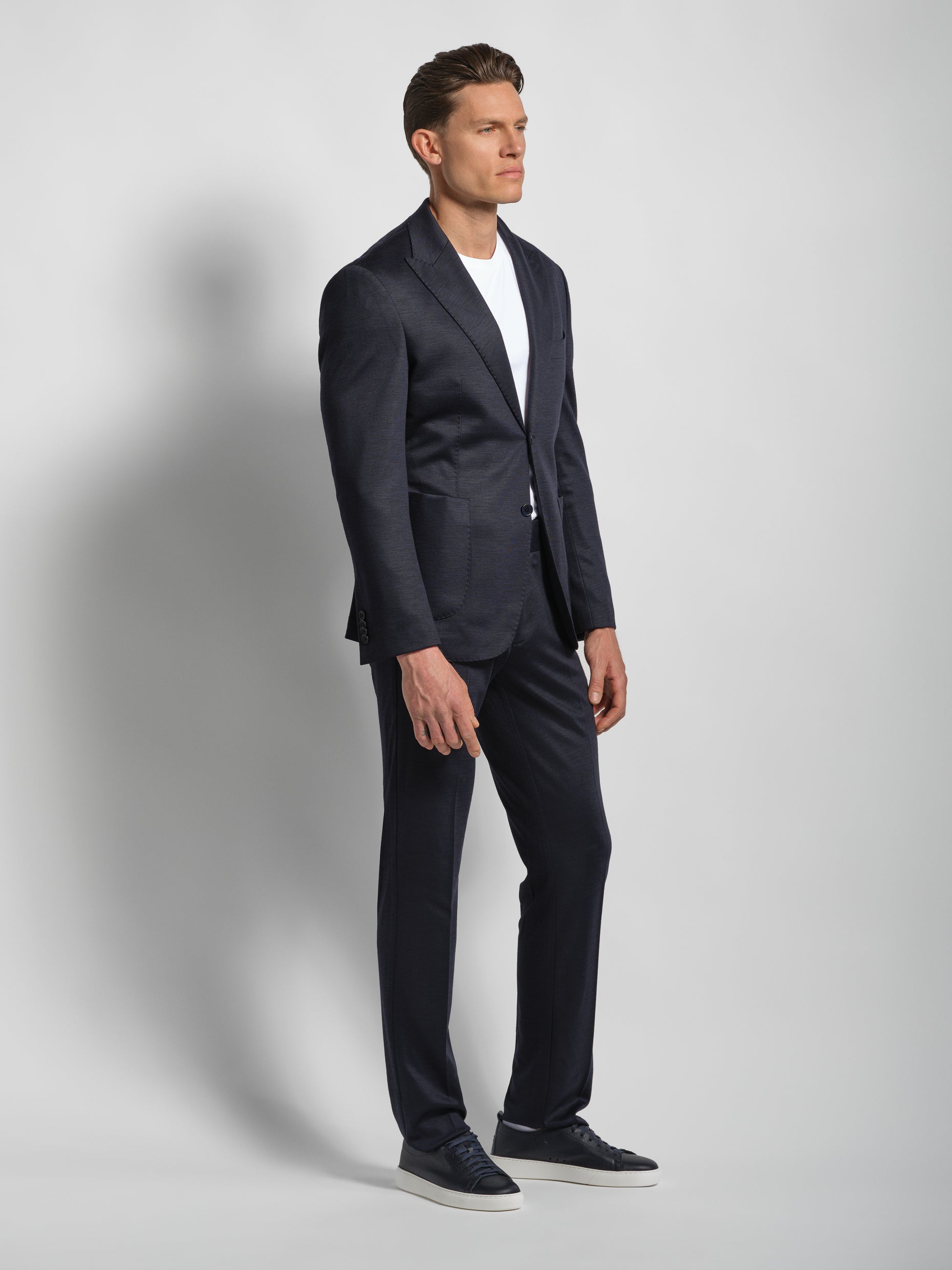 Man wearing a navy jersey suit wide lapels