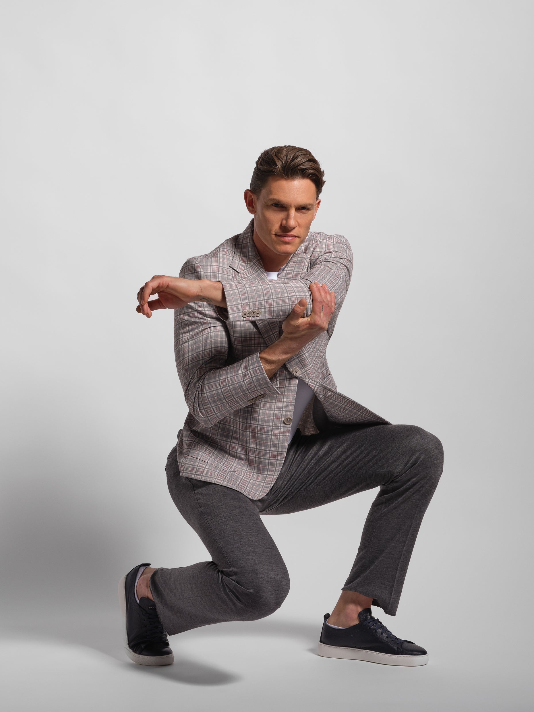 althletic man stretching with grey check multi-colored jersey blazer
