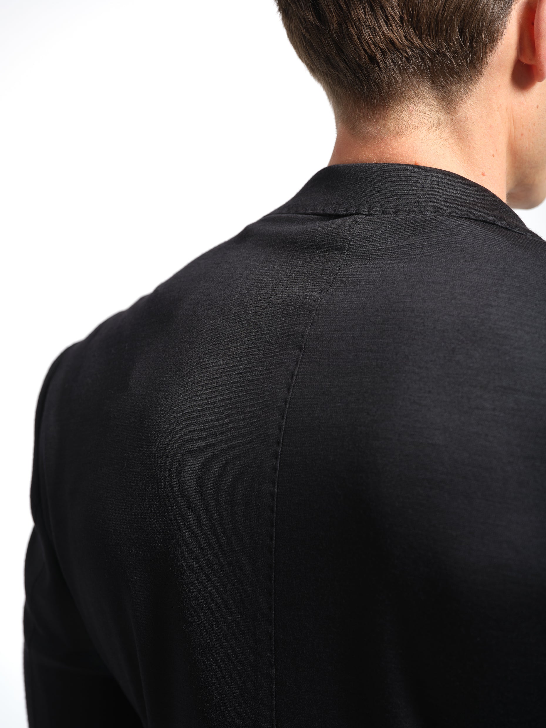 Man wearing a black jersey stretch suit back view top stich 