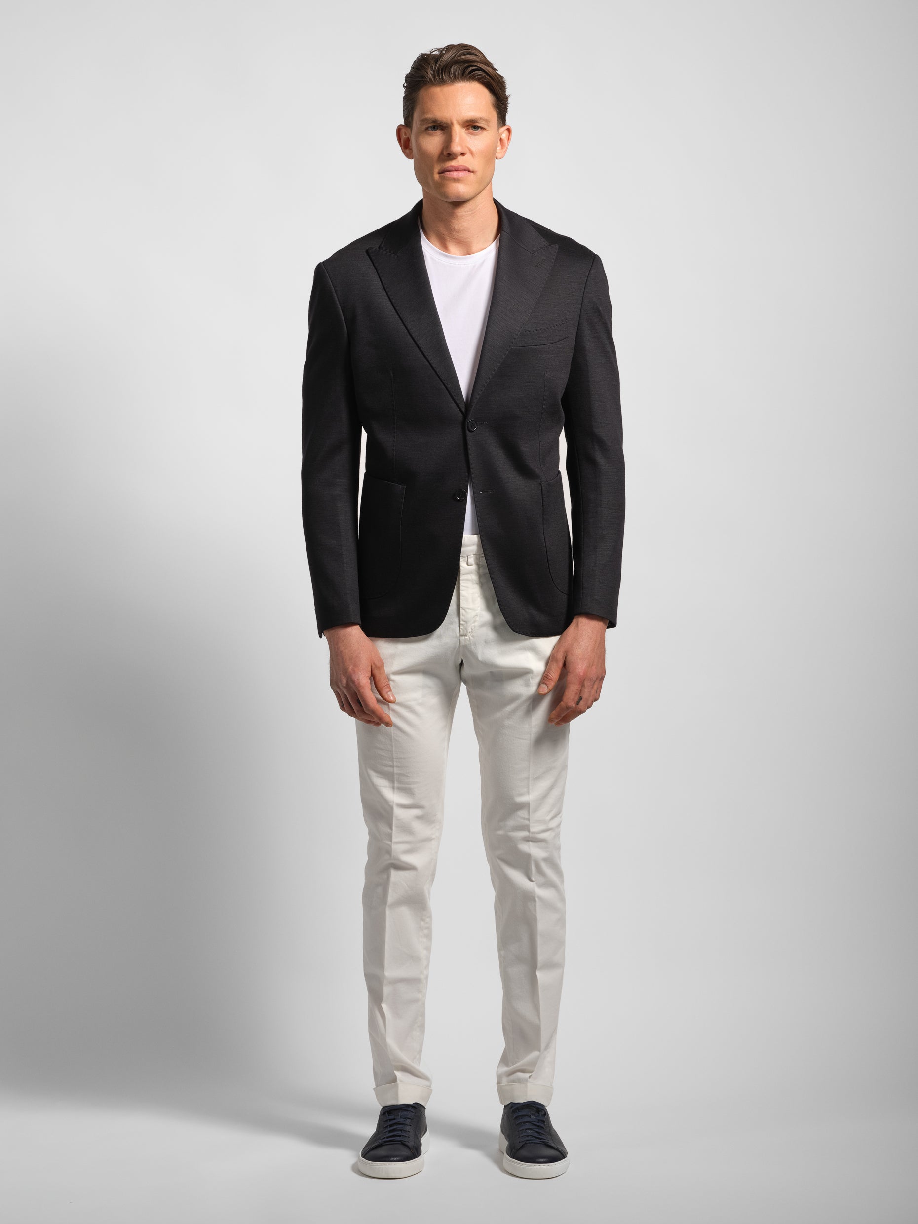 Man wearing a black jersey stretch blazer with white pants