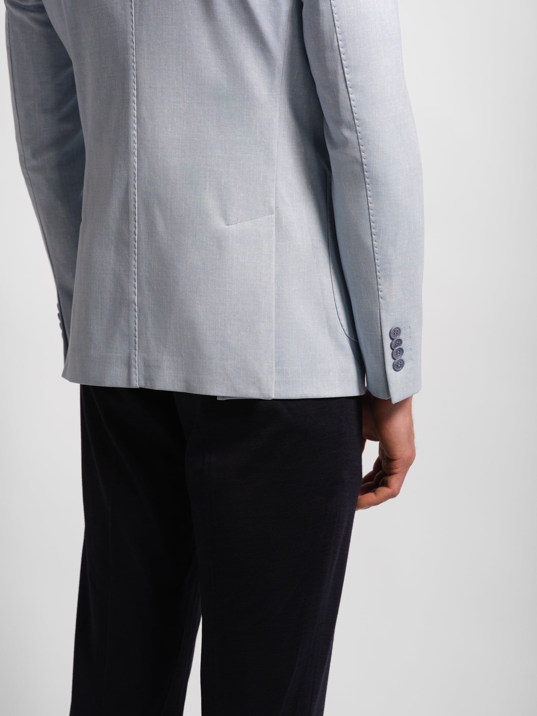 light blue blazer and navy pants on a white background lower area top stich
